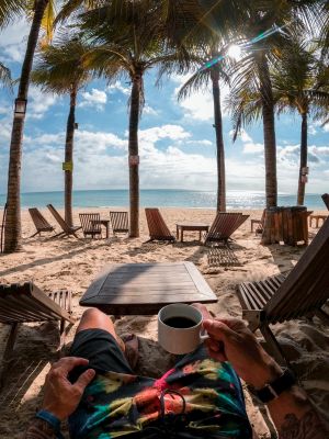 retirement sitting on beach with coffee